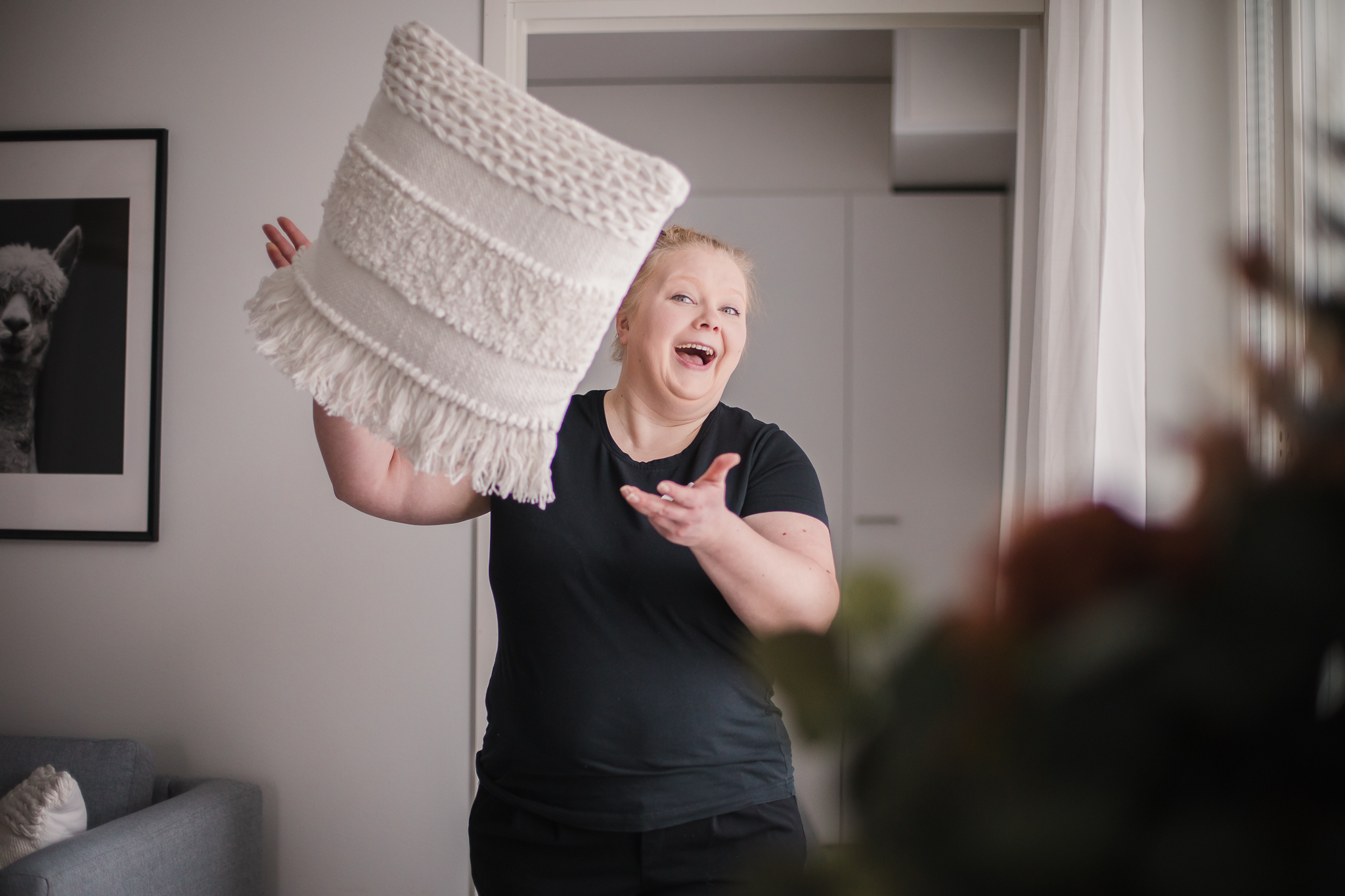 Sisustussuunnittelija Paula Valta heittää kuvassa valkoista tyynyjä ja kertoo, miten valitset kotiisi sopivat tekstiilit.